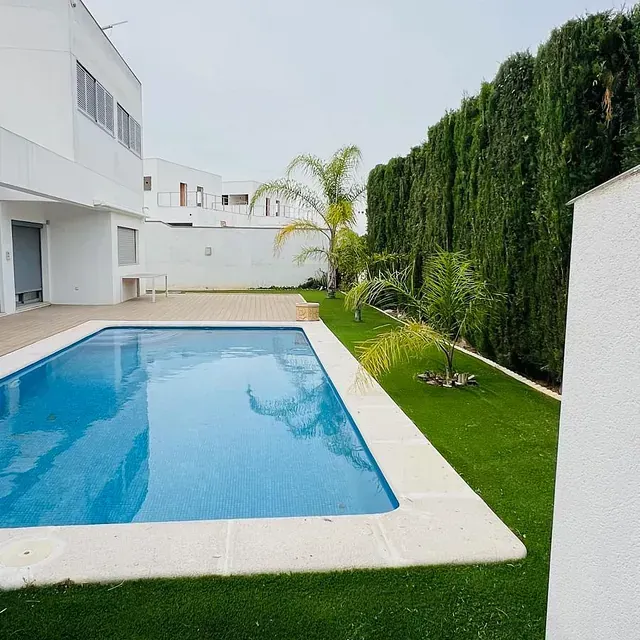 Una gran piscina en el patio trasero de una casa