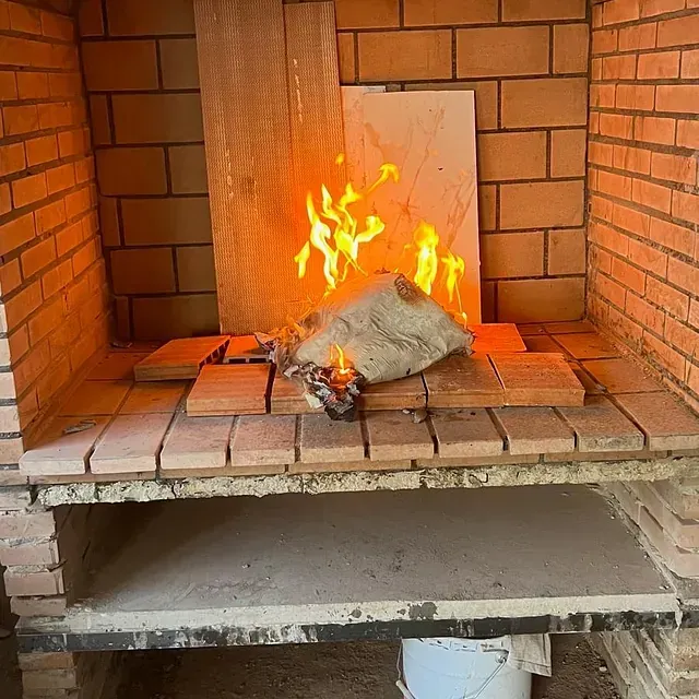 Una chimenea de ladrillo con un trozo de madera encima.