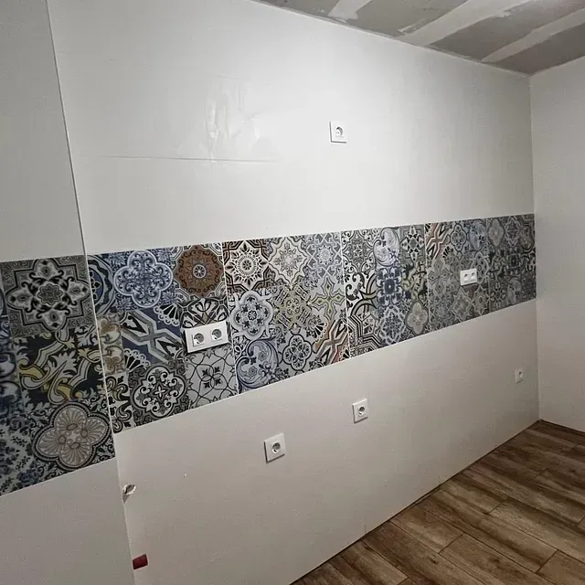 Una cocina con pared de azulejos y suelo de madera.