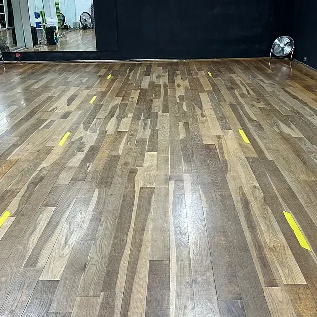 Un piso de madera con líneas amarillas en un estudio de baile.