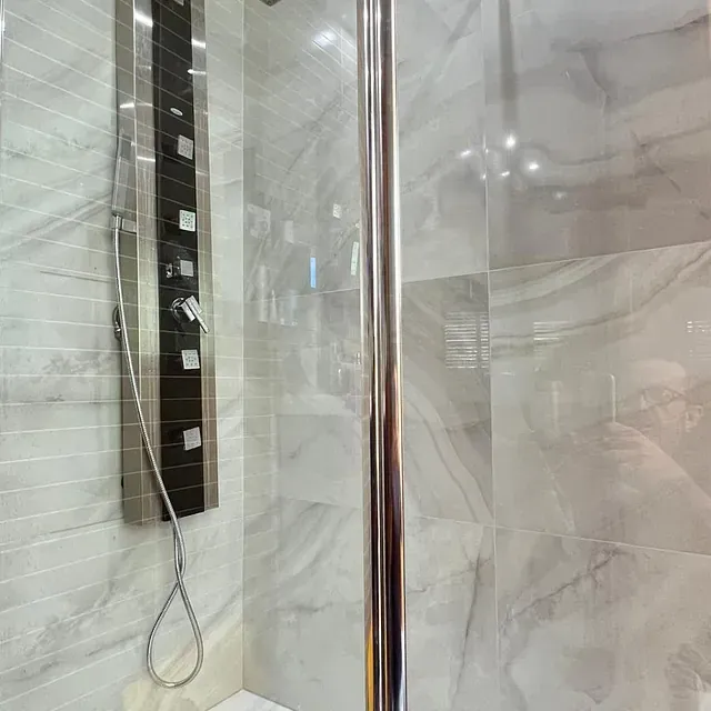 Un baño con cabina de ducha y cabezal de ducha.