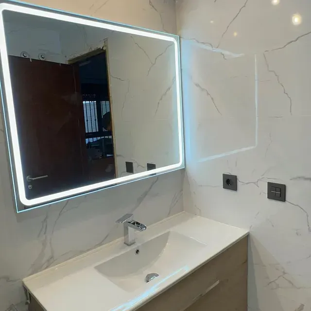 Un baño con lavabo y un espejo grande.