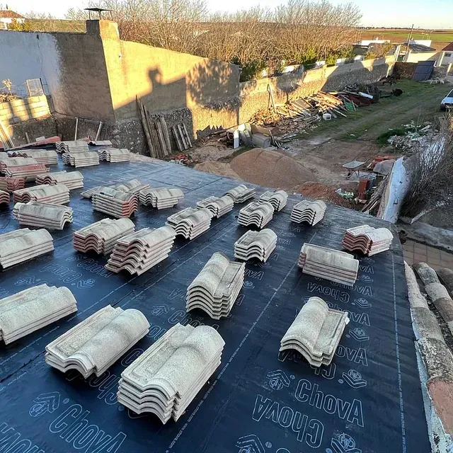 Un montón de tejas están apiladas una encima de otra en un tejado.