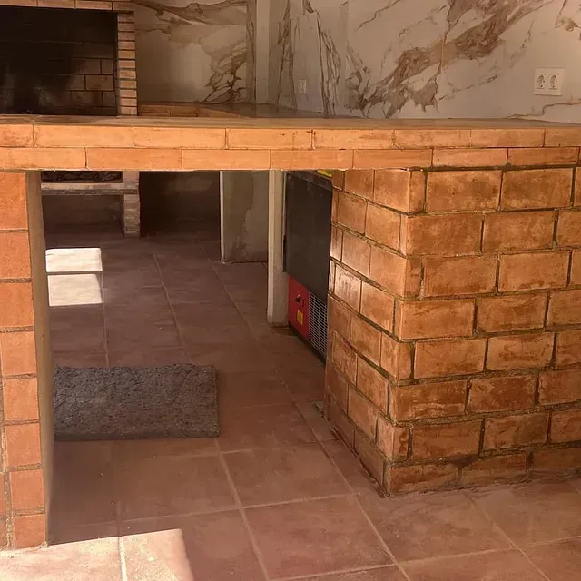 Una cocina con encimera de ladrillo y chimenea.