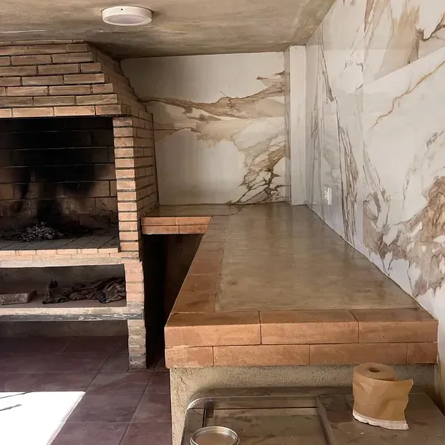 Una habitación con chimenea de ladrillo y una pared de mármol.