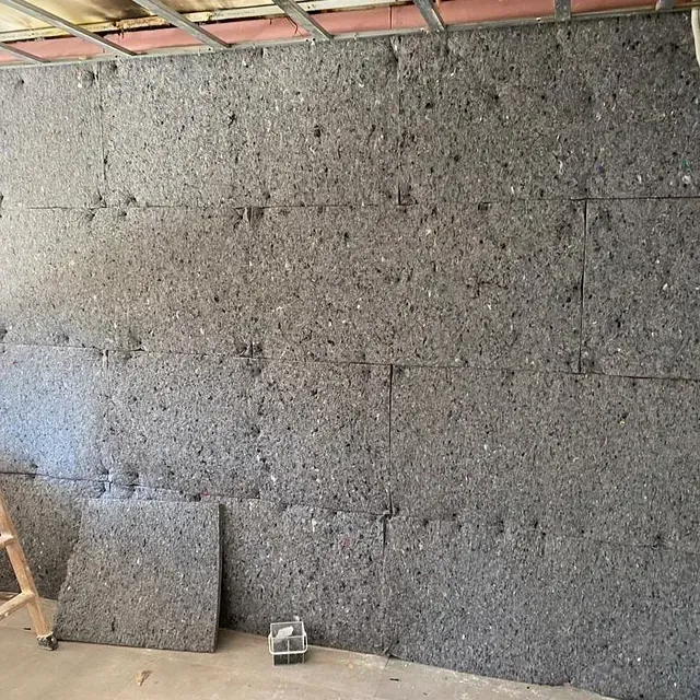 Una persona está parada frente a una pared cubierta de espuma.