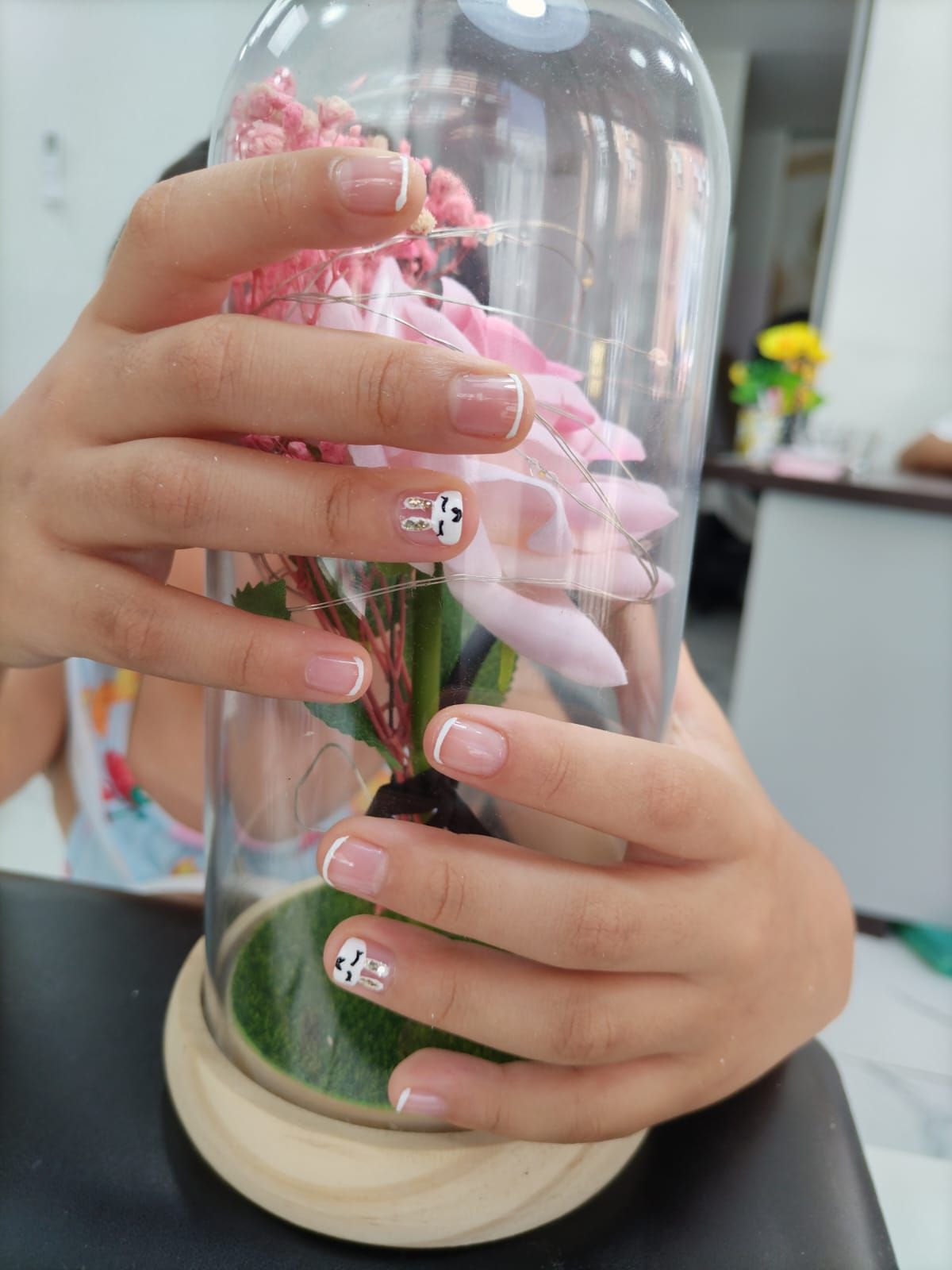 Una persona sostiene una flor rosa en una cúpula de cristal.
