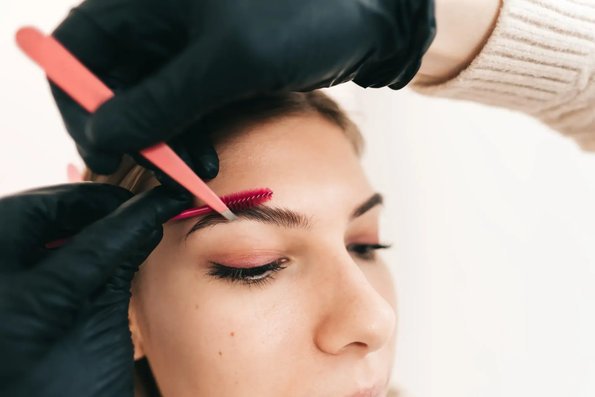 Una mujer se está haciendo un maquillaje para las cejas.
