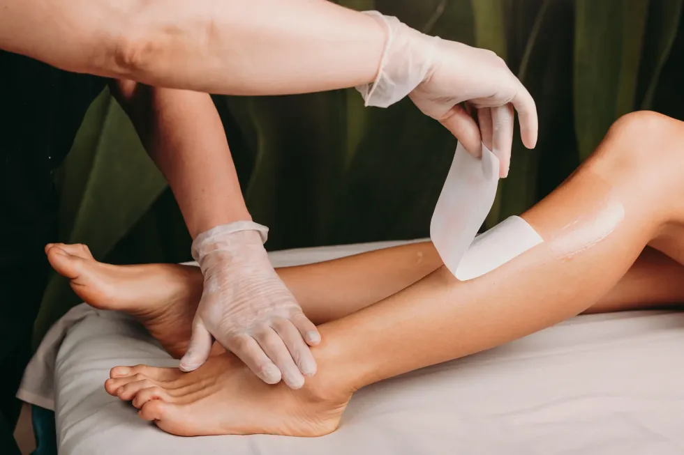 Una mujer se depila las piernas en un salón de belleza.