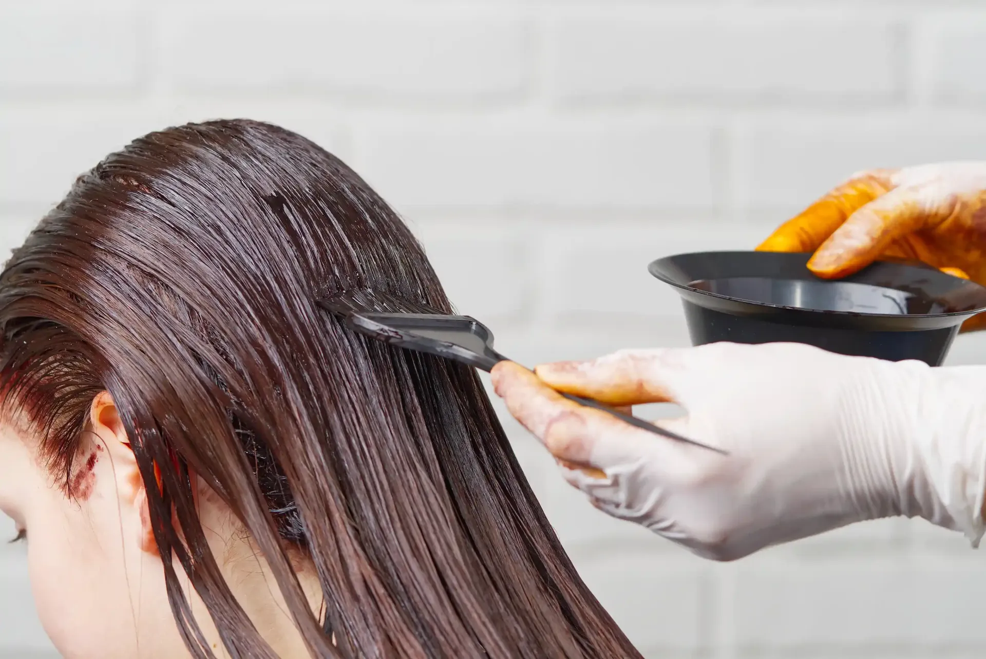 Una mujer se está tiñendo el pelo en la peluquería.
