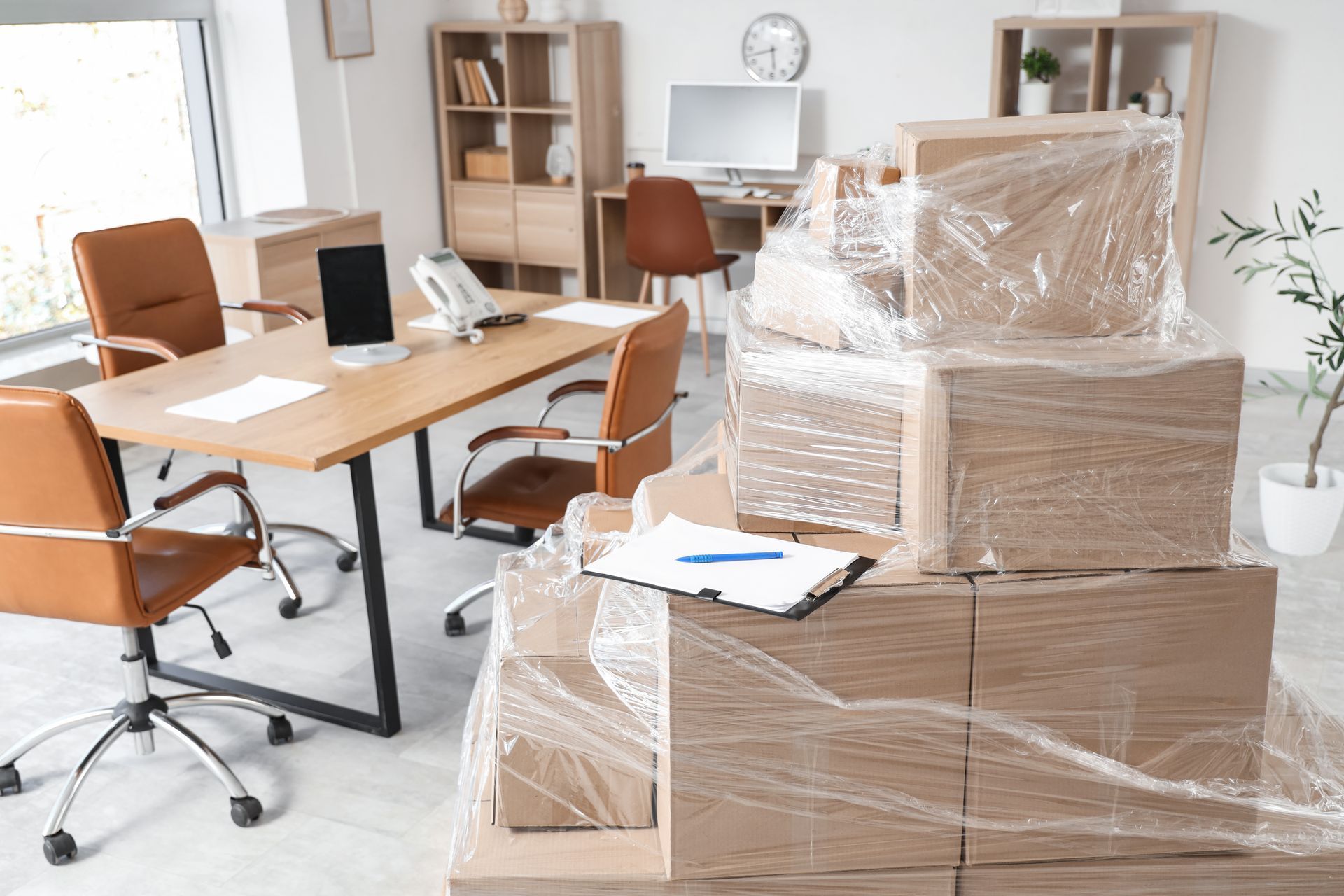 Espace de travail avec des piles de cartons emballés dans du plastique.