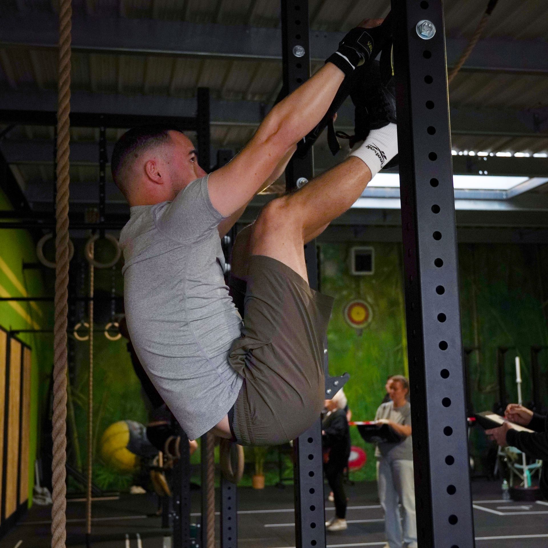 Un gros plan d'une paire d'anneaux de gymnastique suspendus à un poteau dans une salle de sport.