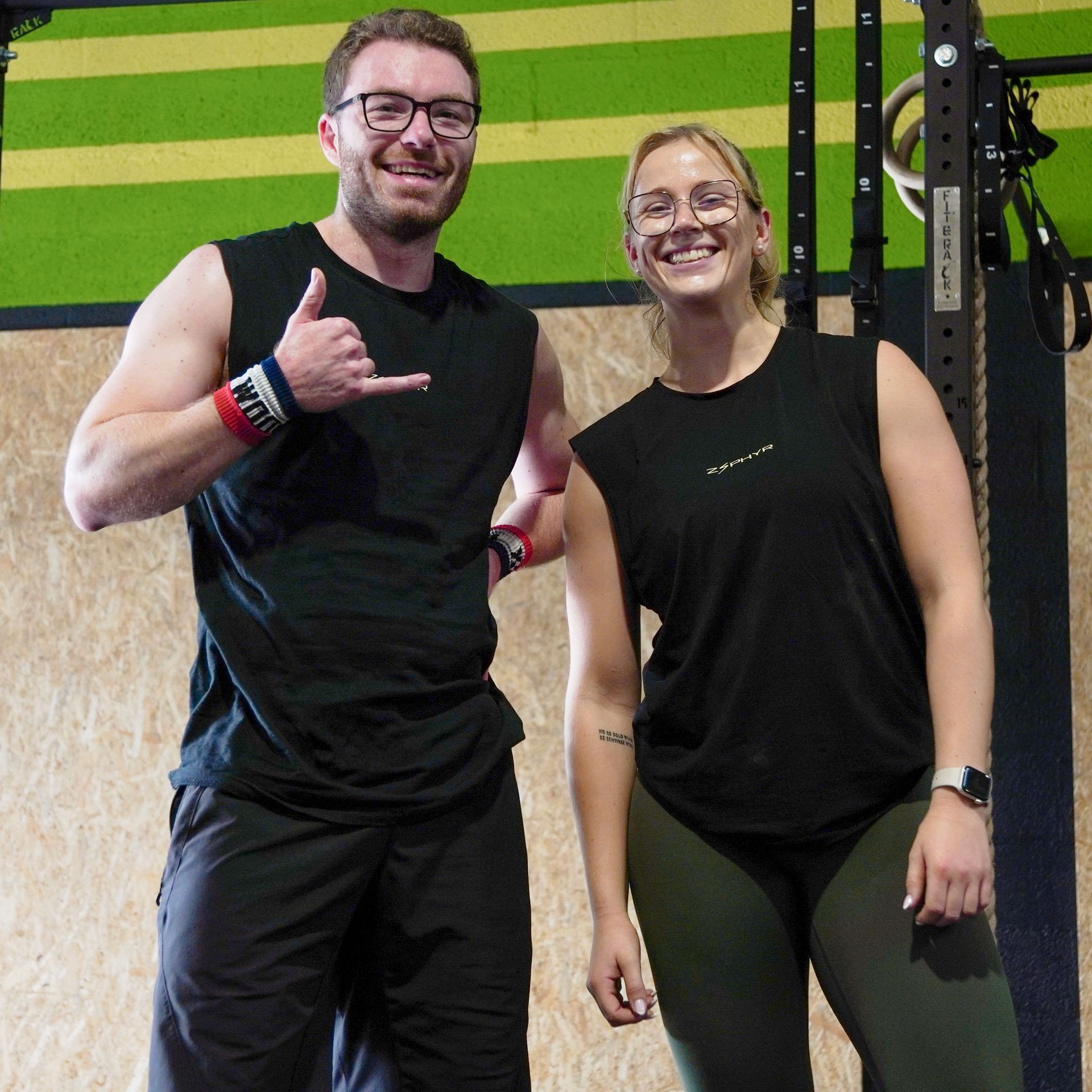 Un homme et une femme font des exercices avec des kettlebells dans une salle de sport.