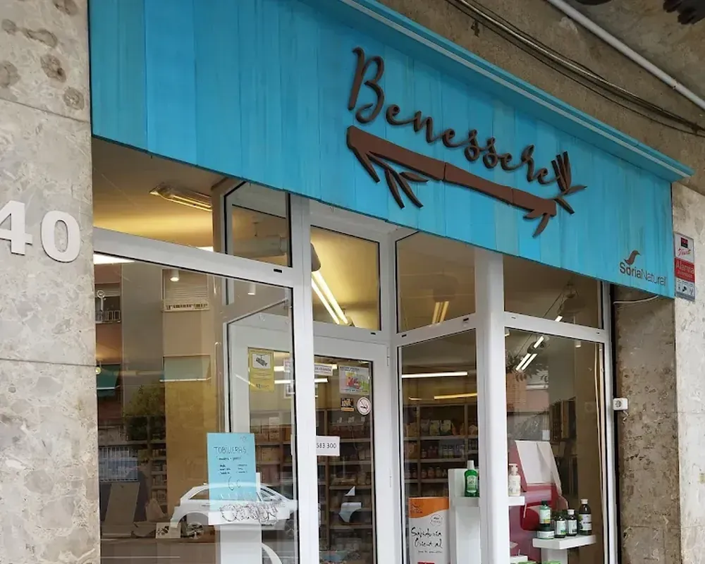 Fachada con toldo verde azulado y letrero 