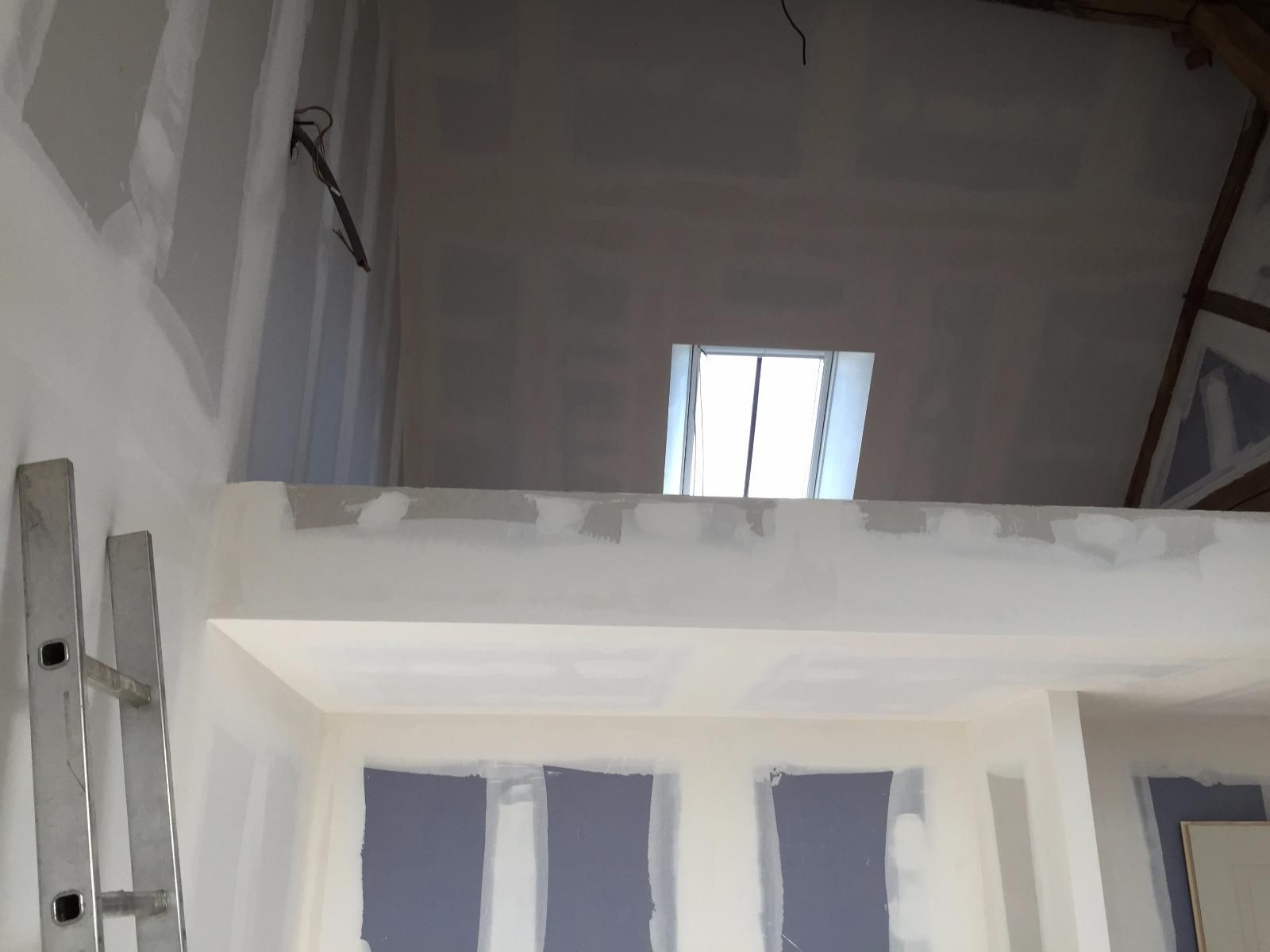 Intérieur en cours d'aménagement avec cloisons sèches et puits de lumière.