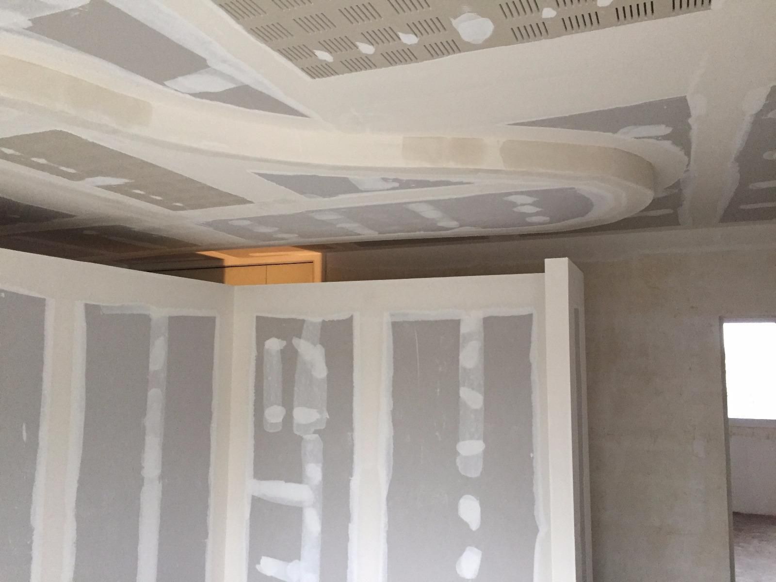 Pose de plaques de plâtre en cours ; conception de plafond incurvé ; murs recouverts de plaques de plâtre.