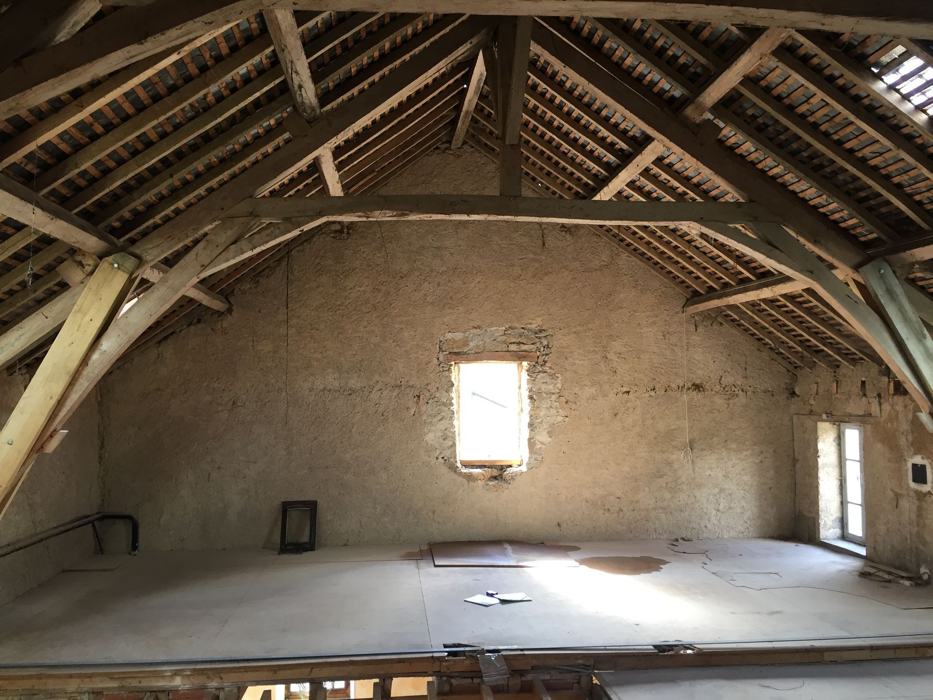 Intérieur d'un vieux grenier. Les poutres et chevrons apparents soutiennent le toit. 