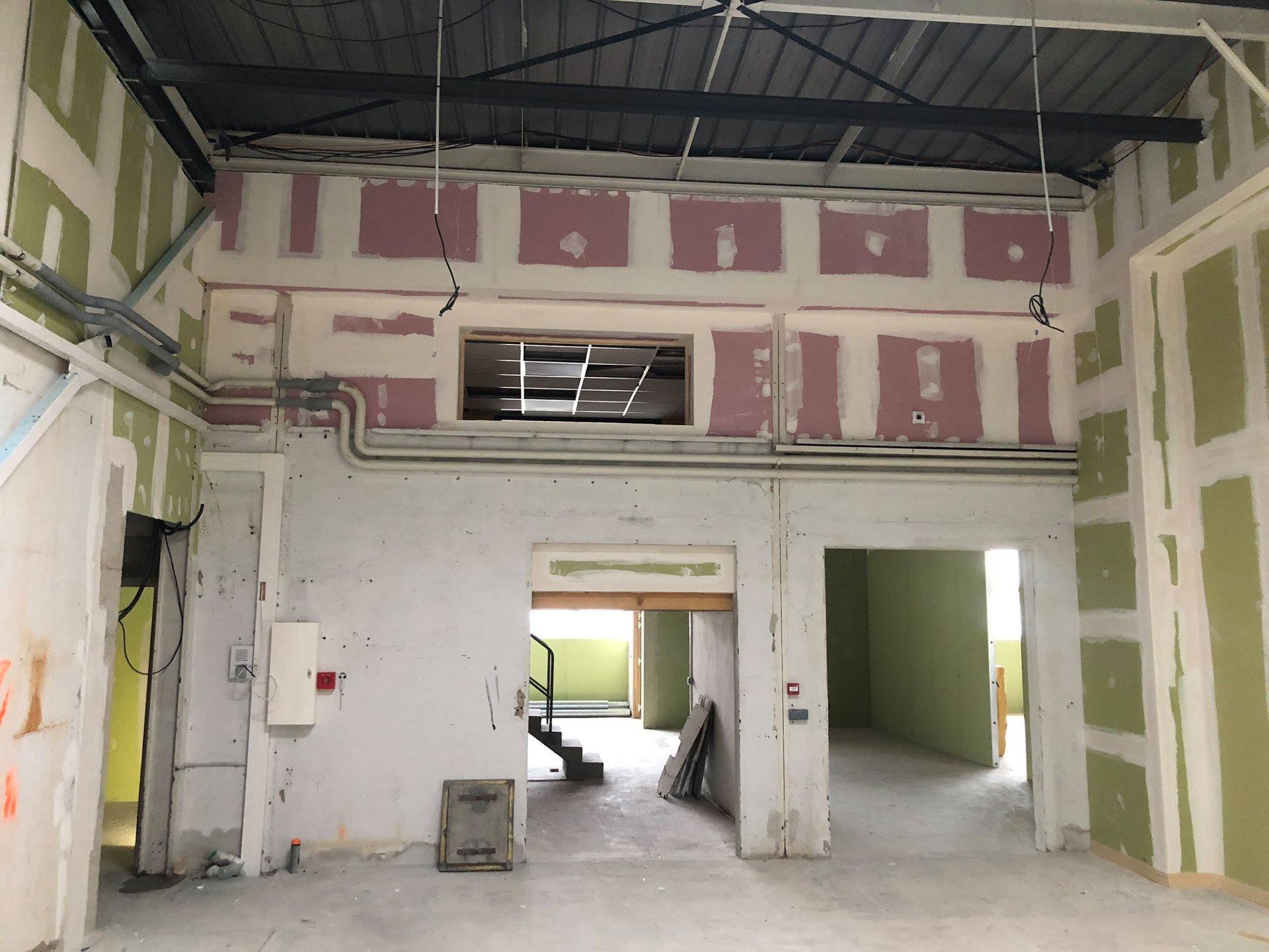 Intérieur d'un bâtiment en construction, avec murs inachevés et câblages électriques.