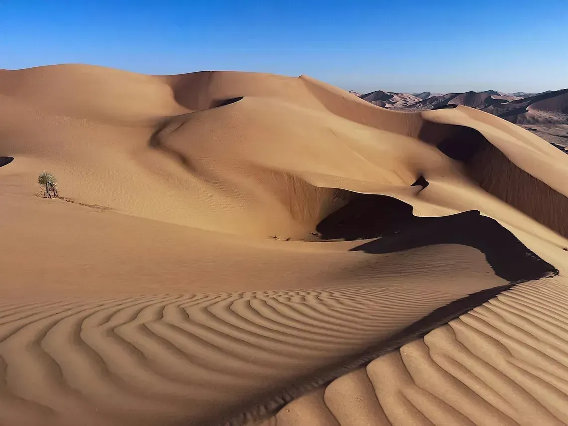 Dunas de arena en el desierto con un cielo azul de fondo