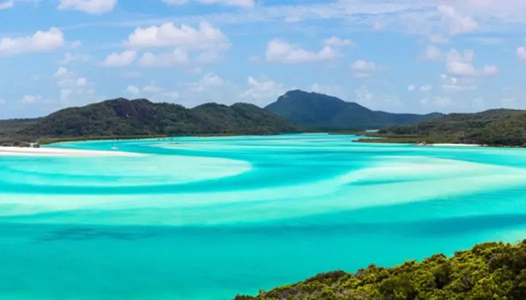 Un gran cuerpo de agua rodeado de montañas y árboles.