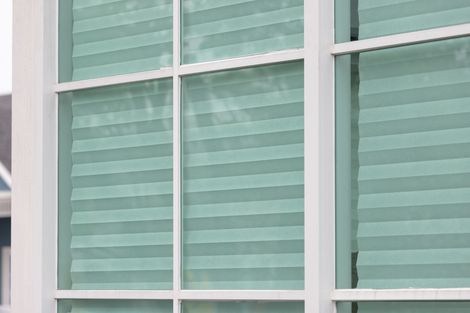 Eine Nahaufnahme eines Fensters mit grünen Jalousien.