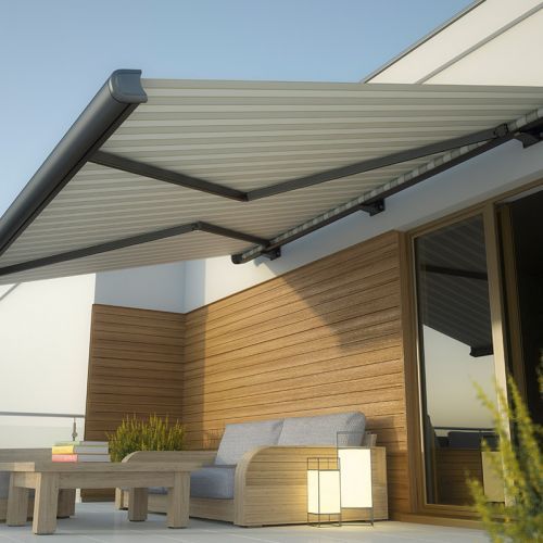 Eine Terrasse mit Couch und Tisch unter einer Markise