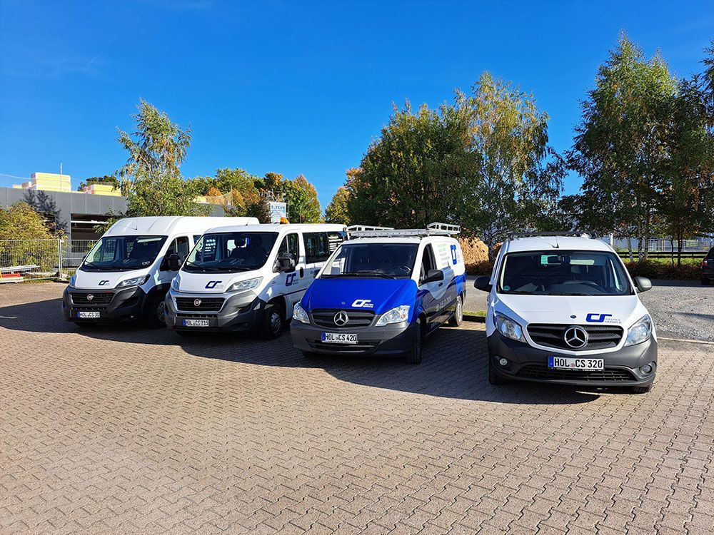 Auf einem Parkplatz steht eine Reihe Lieferwagen.