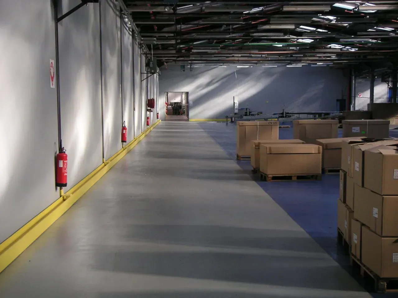 Entrepôt avec un sol gris, jaune et bleu