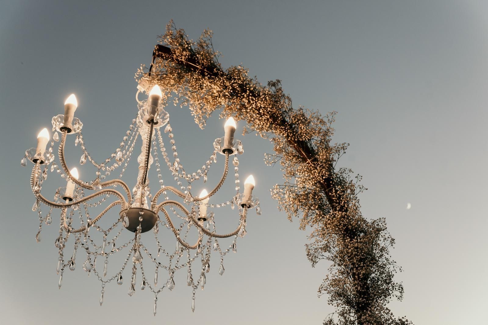 Un candelabro con velas colgando contra un cielo azul.