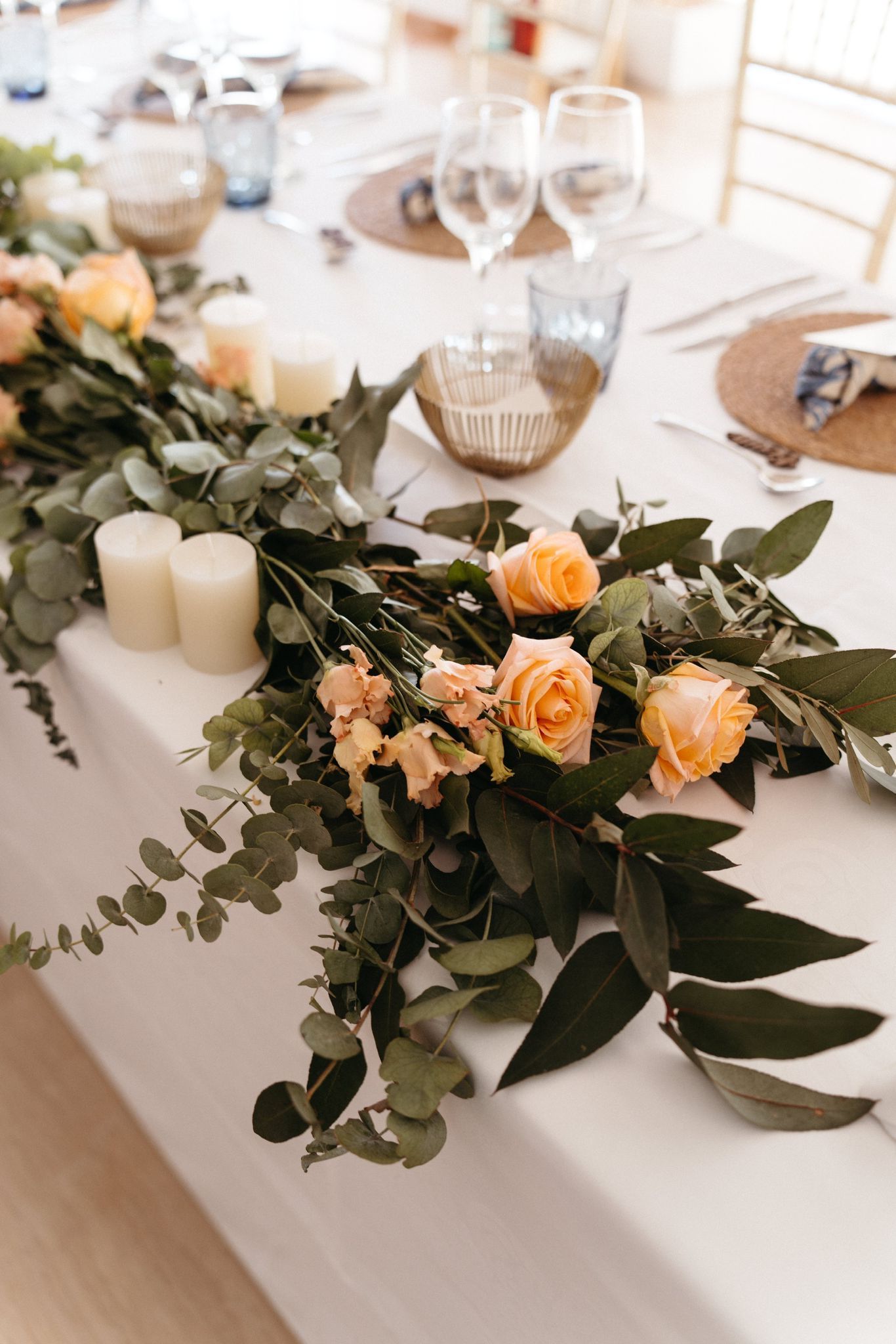 Una mesa larga con flores y velas.