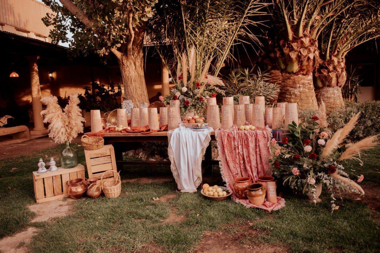 Una mesa con flores y jarrones está colocada en el césped.