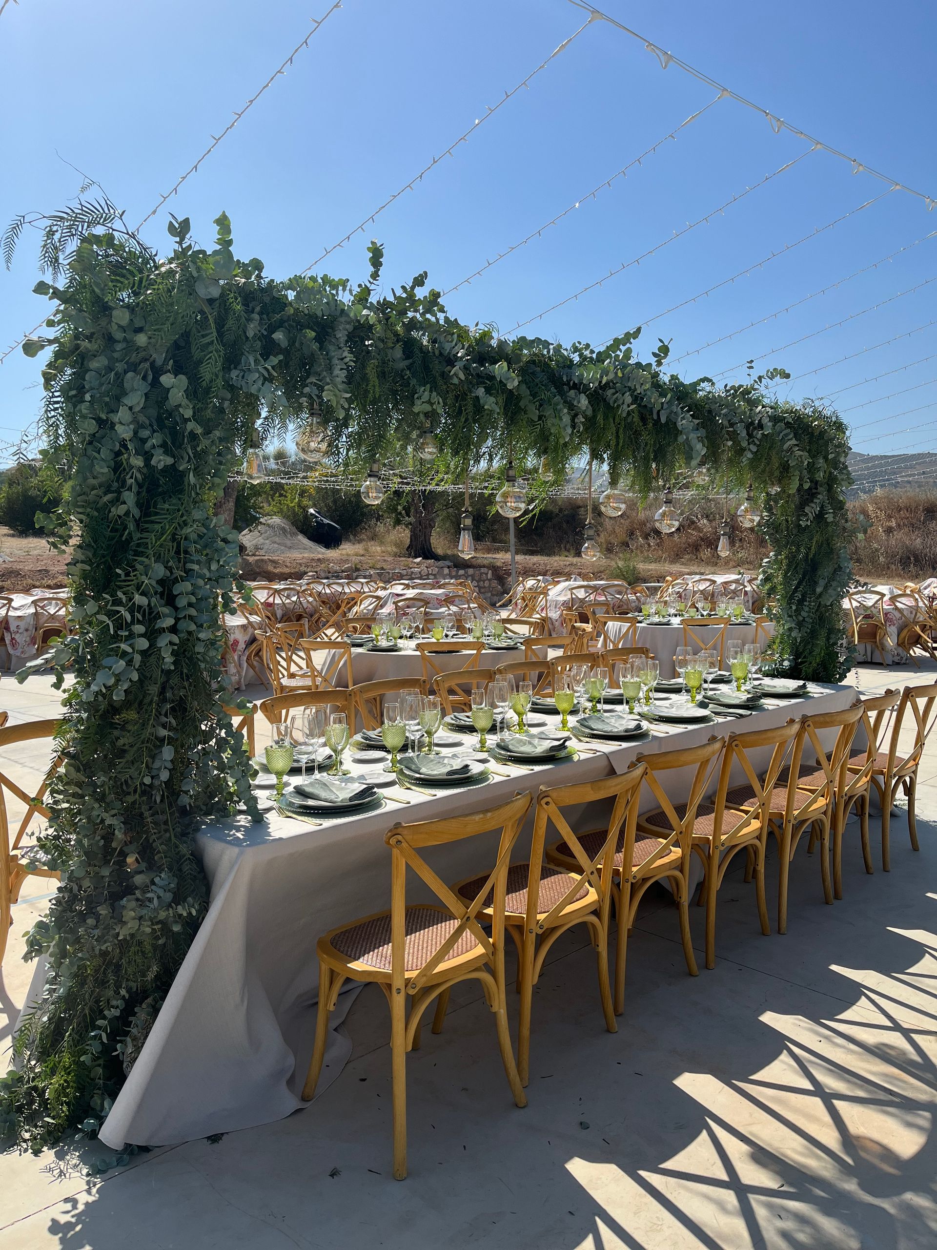 Se preparan una mesa larga y sillas para la recepción de una boda.