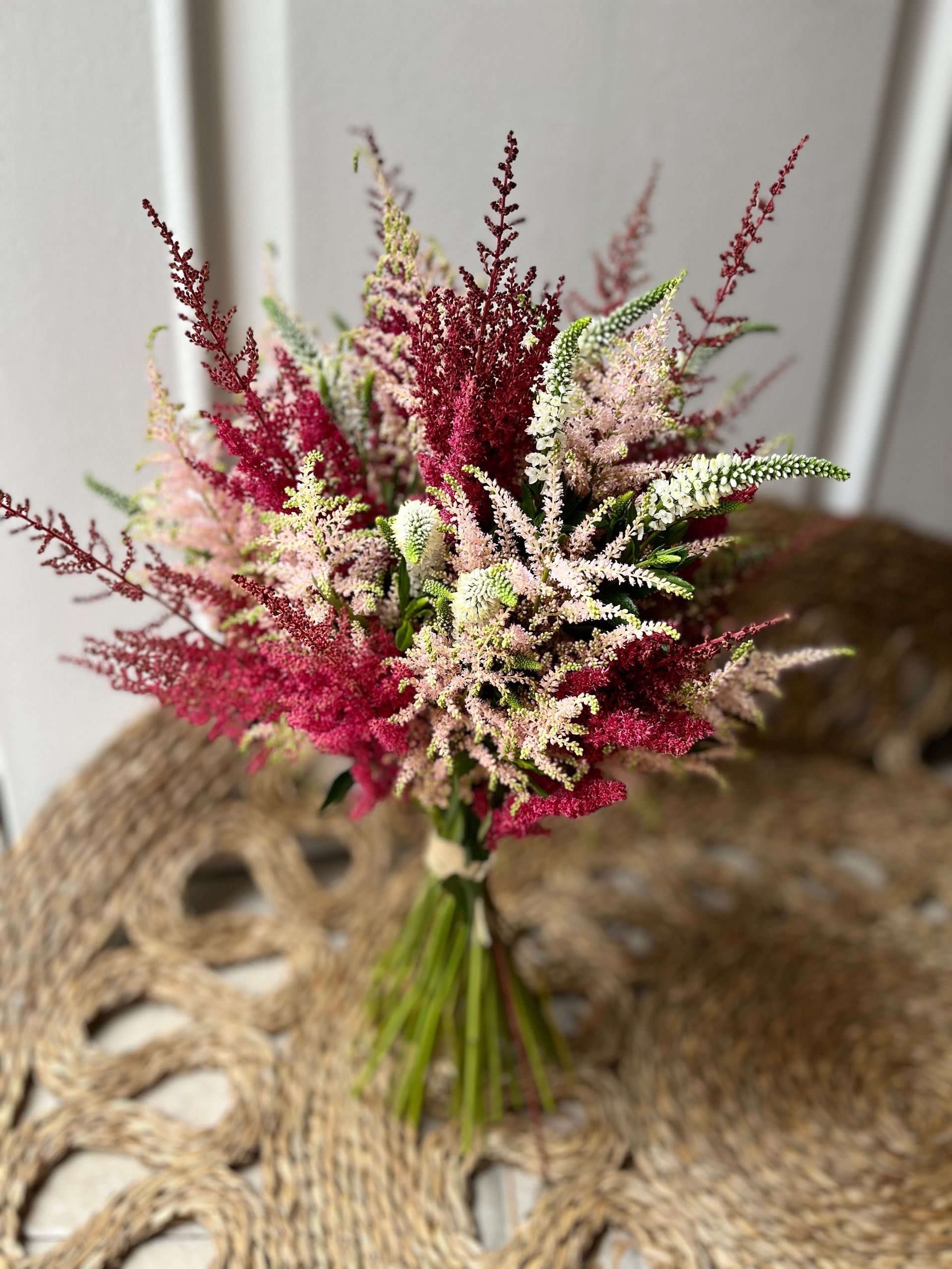 Un ramo de flores rosas y blancas está sobre una mesa.