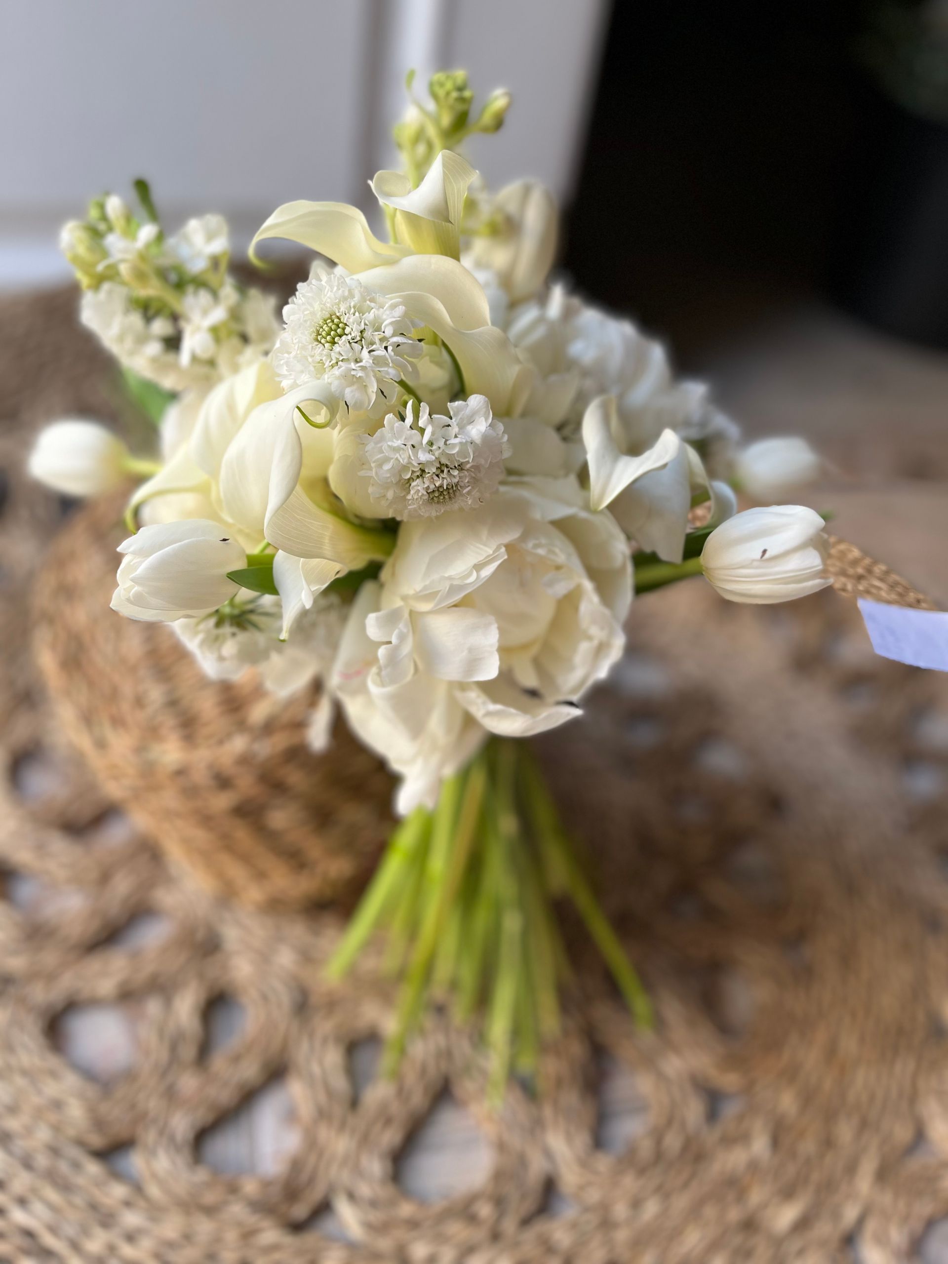 Un ramo de flores blancas está sobre una mesa.