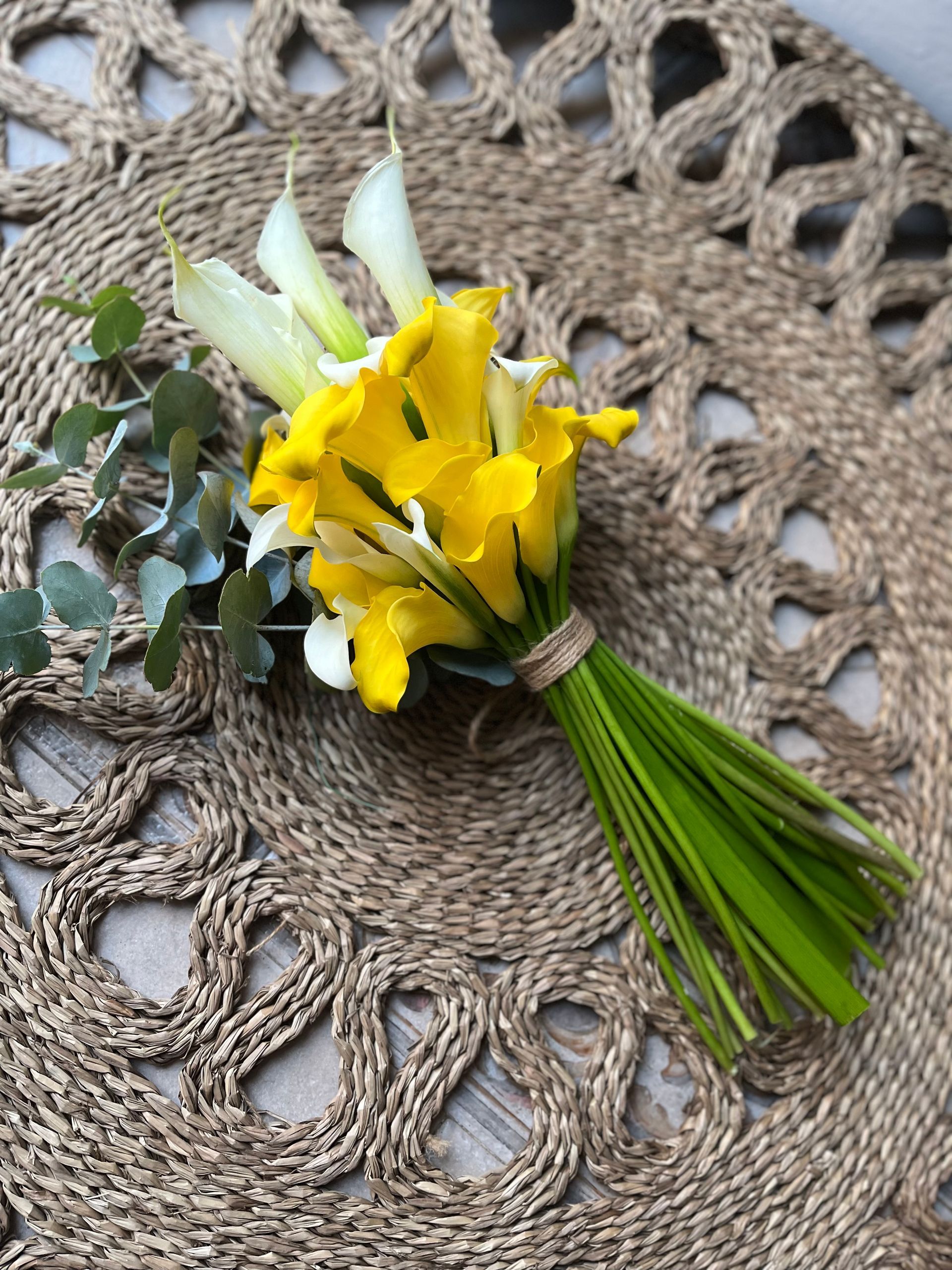 Un ramo de flores amarillas y blancas reposa sobre un mantel.