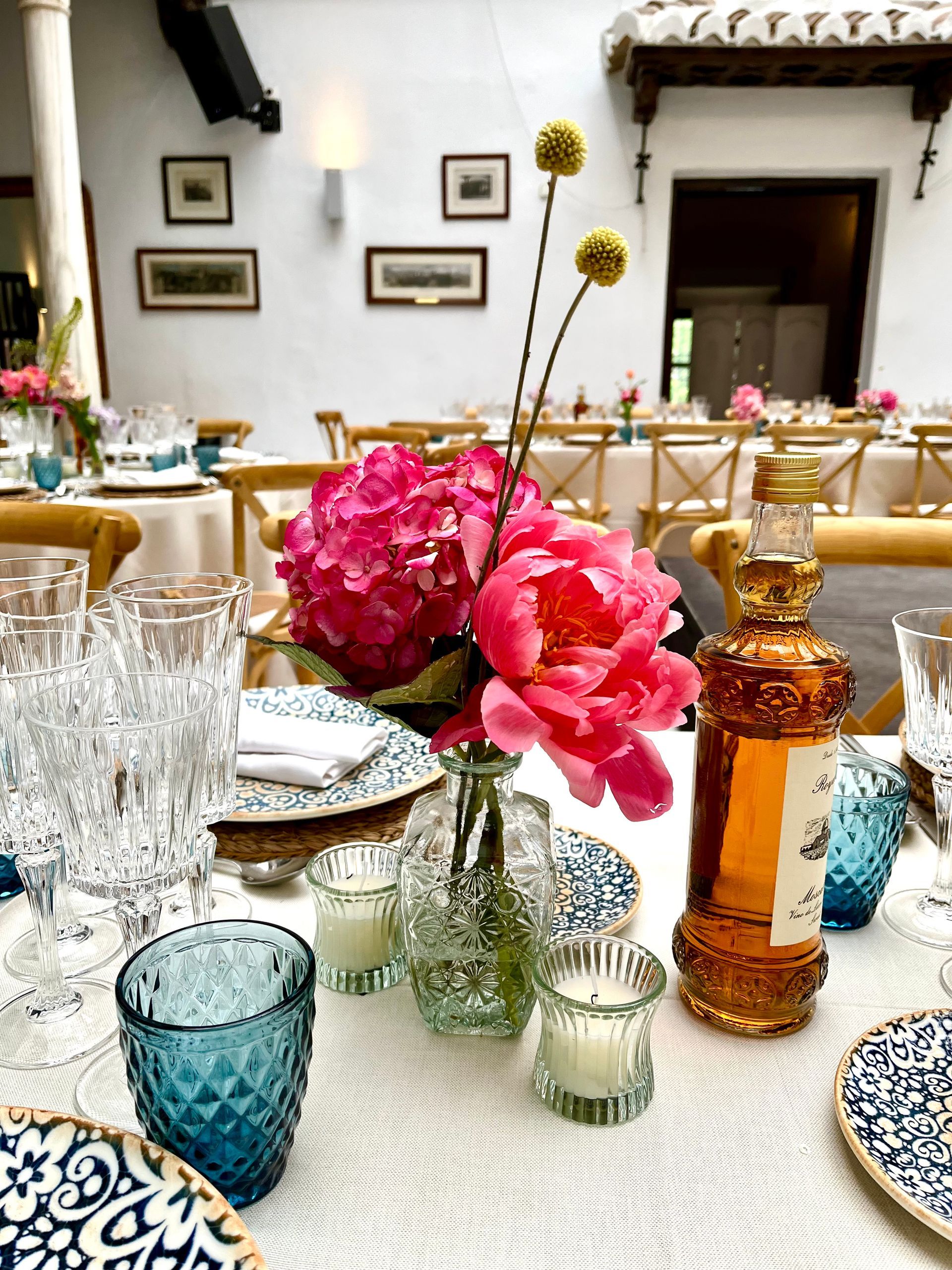 Una mesa con platos, vasos, velas y flores sobre ella.