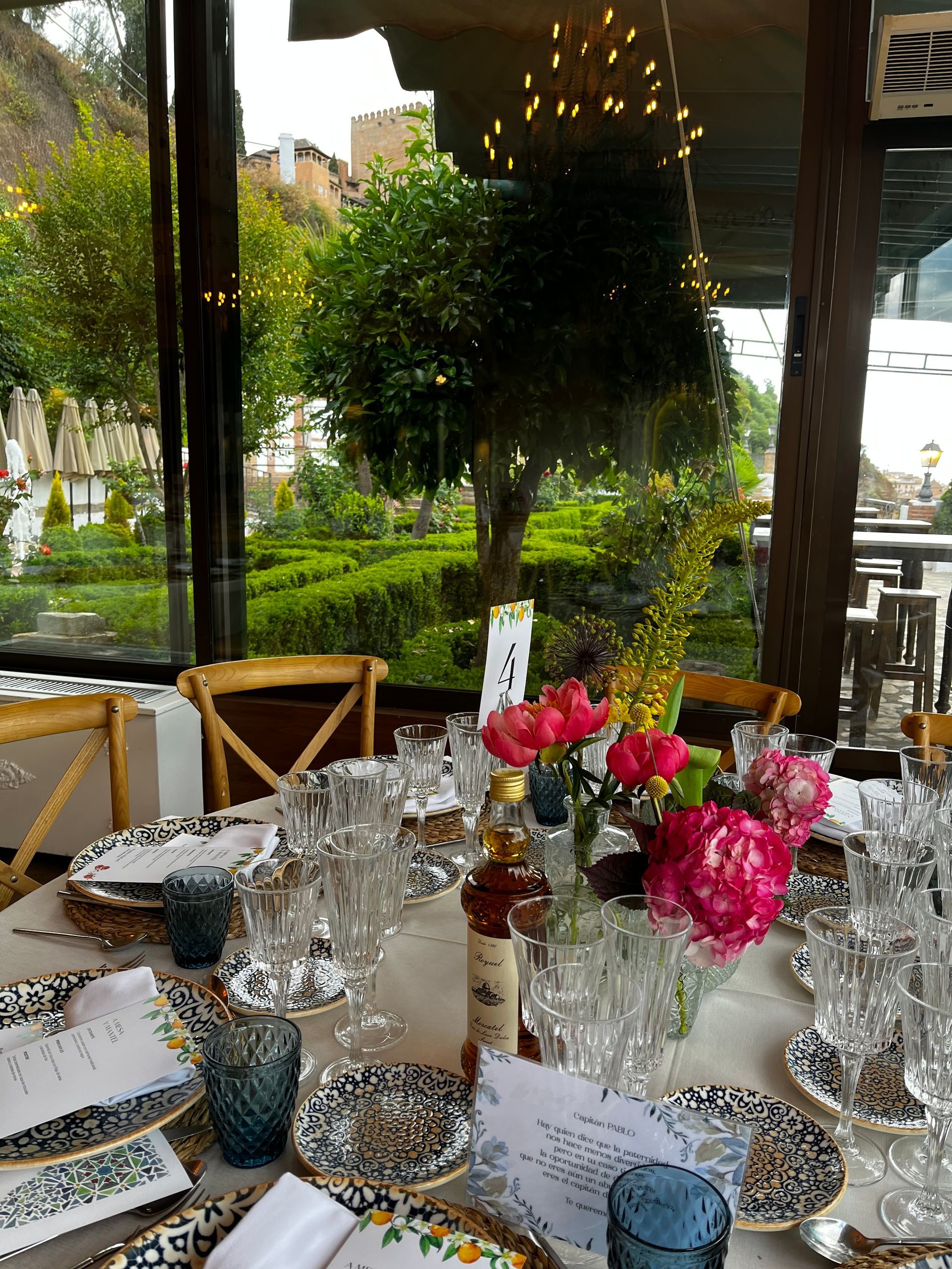 Una mesa con platos, vasos y flores sobre ella.