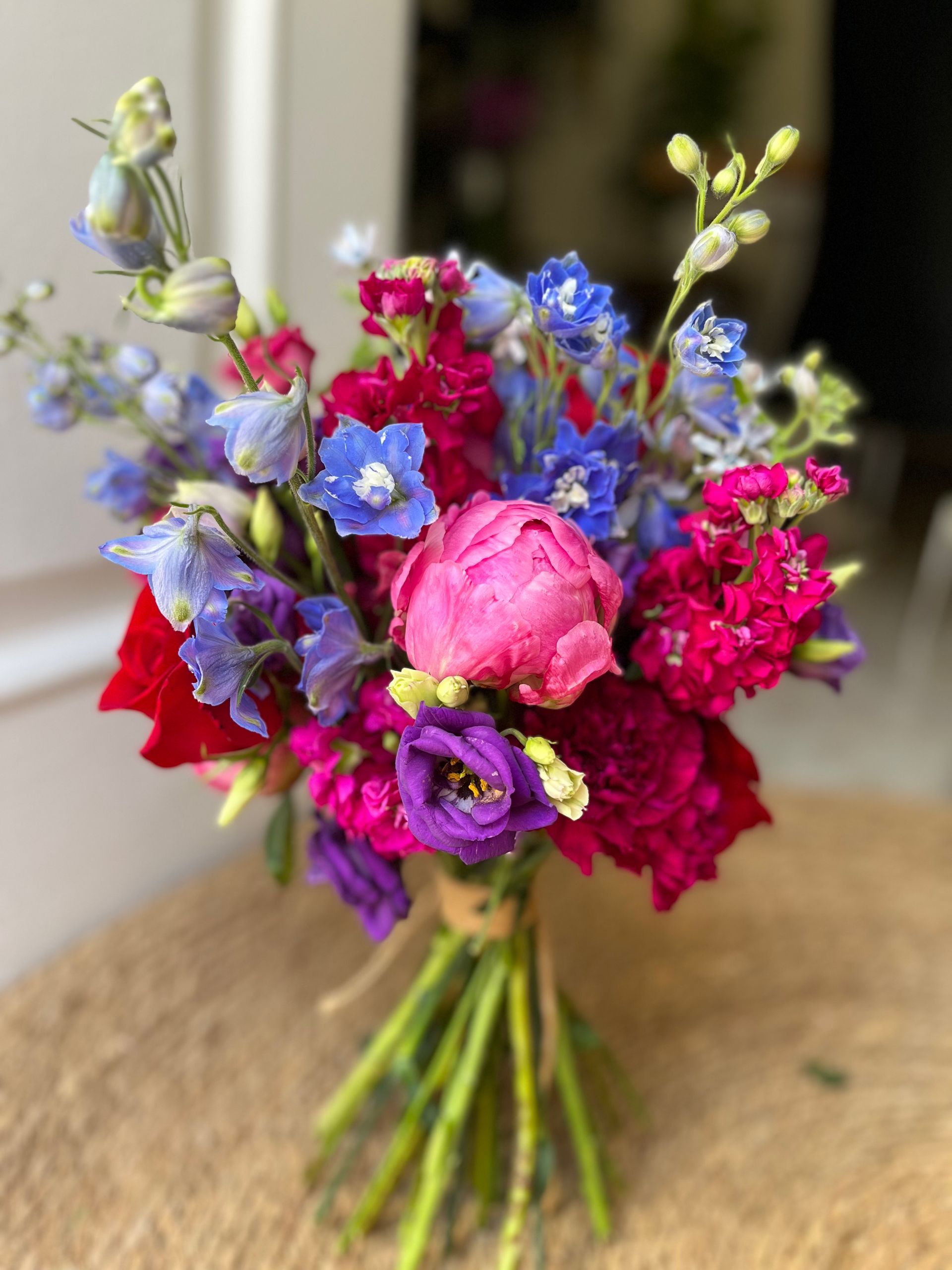 Un ramo de flores de colores está sobre una mesa.