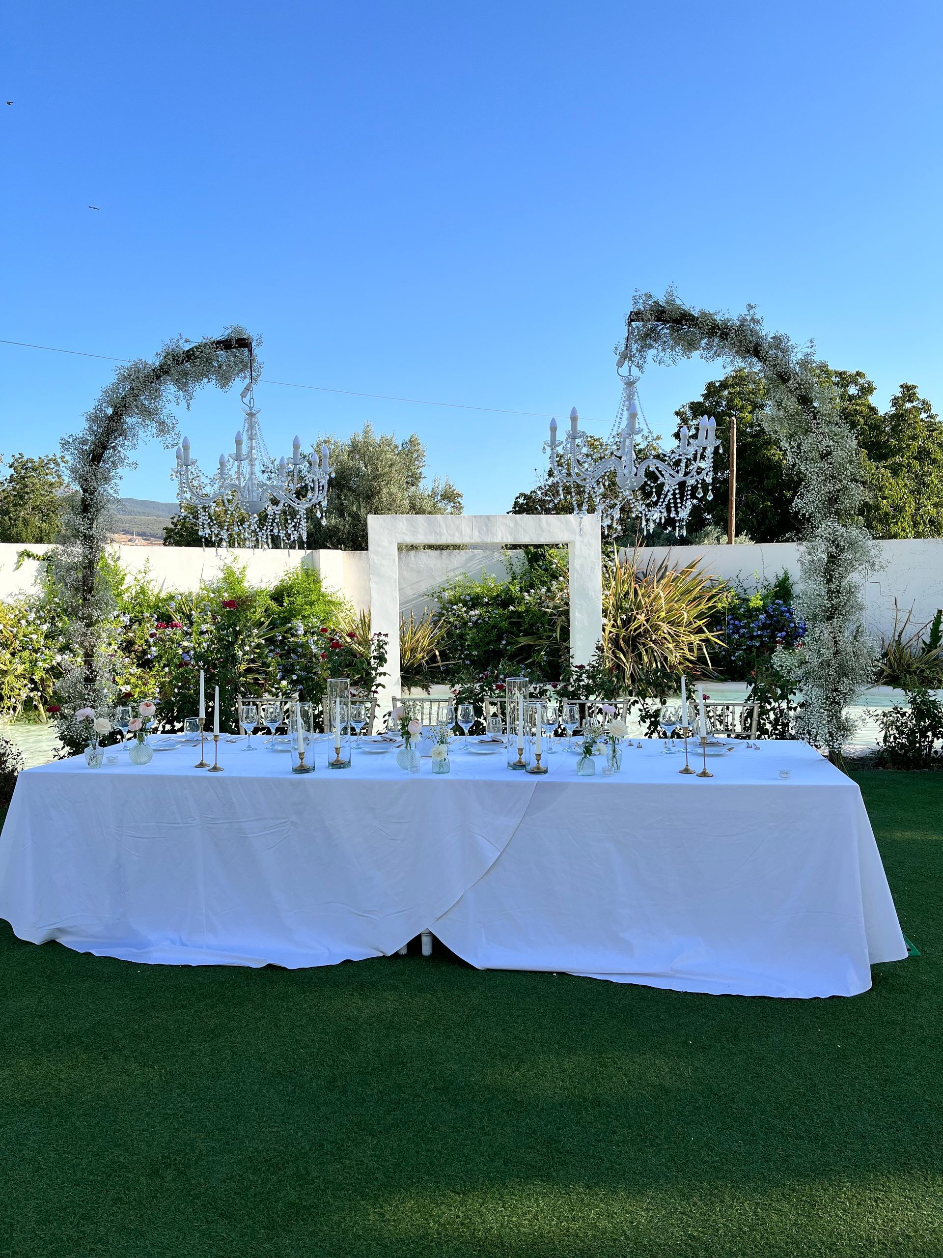 Una mesa blanca con velas y flores.