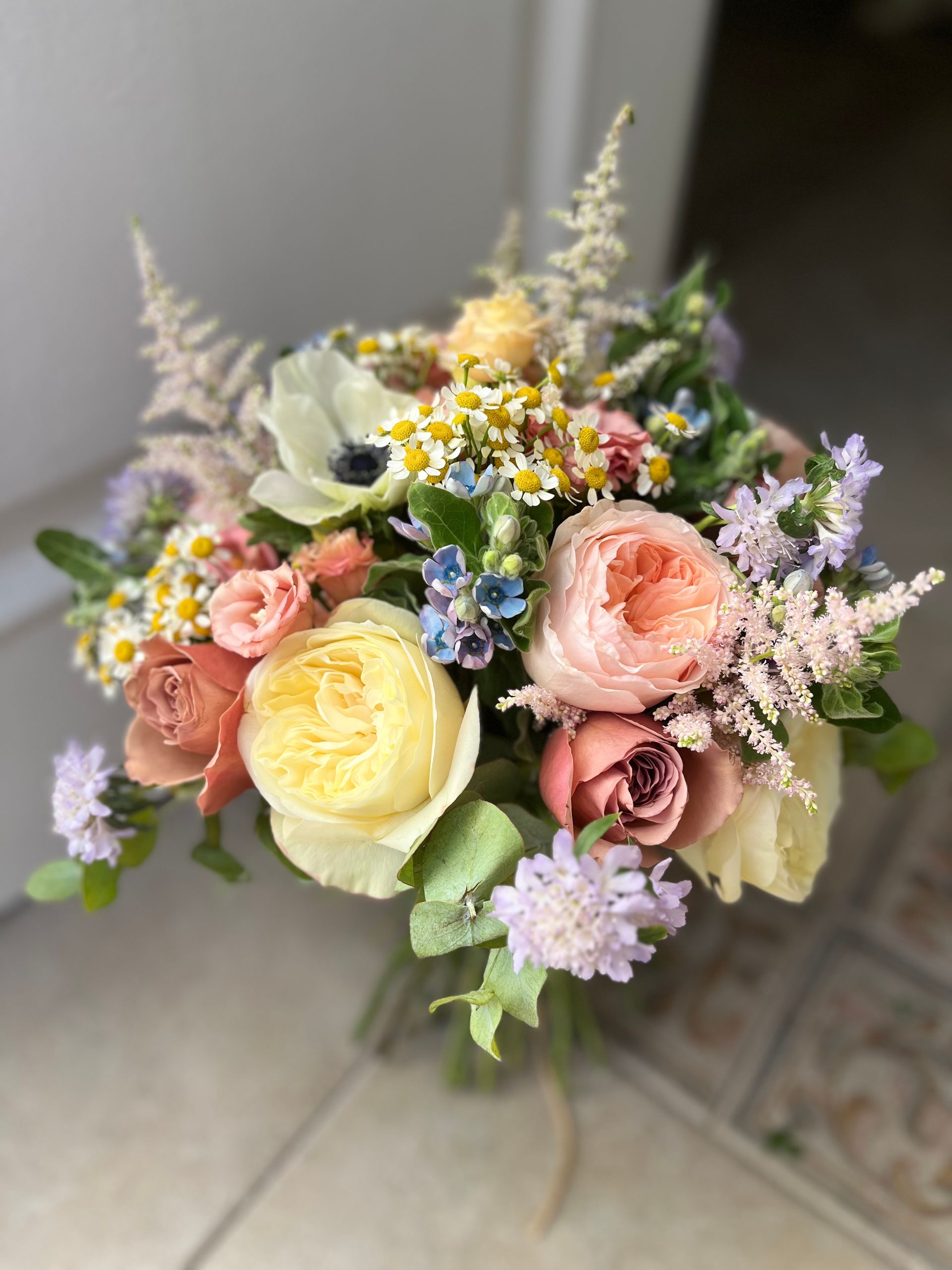 Un ramo de flores está sobre un suelo de baldosas.