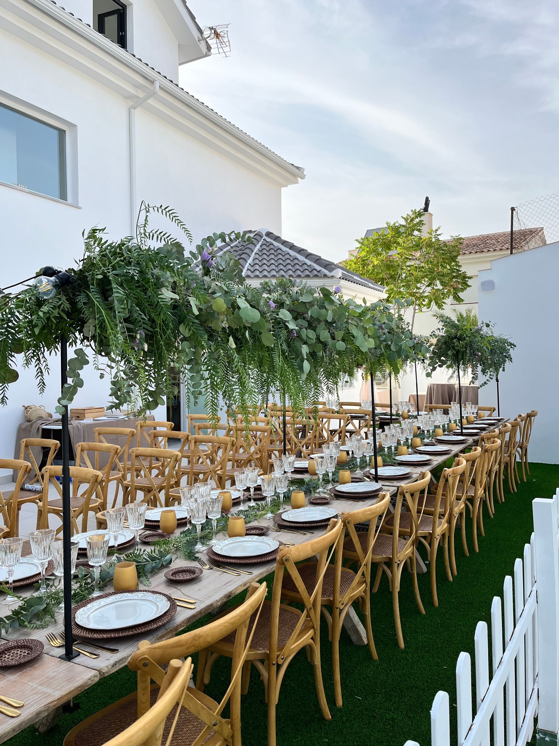 Una mesa larga con platos y sombrillas sobre ella.