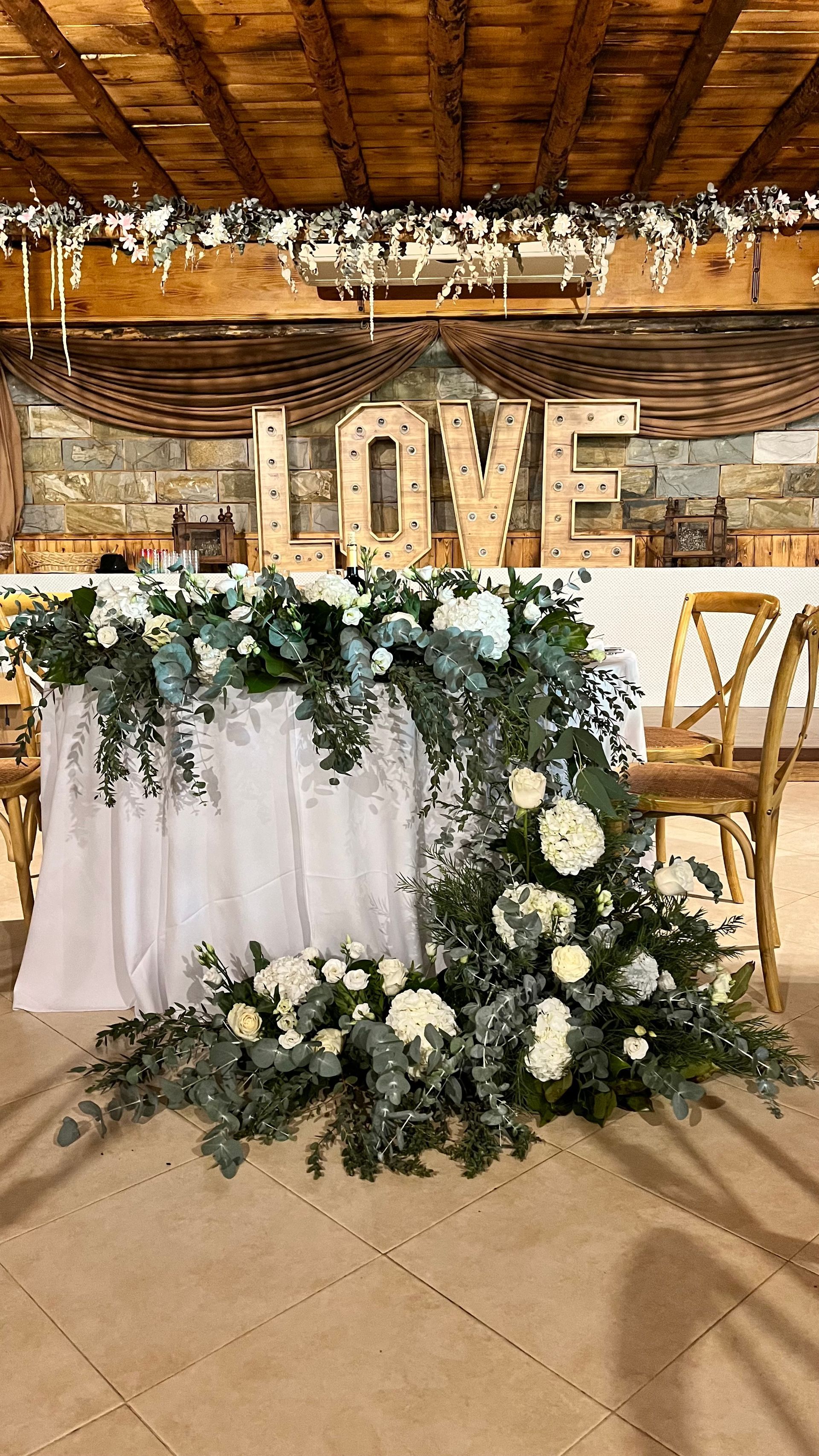 Una mesa larga con flores y un símbolo de amor sobre ella.