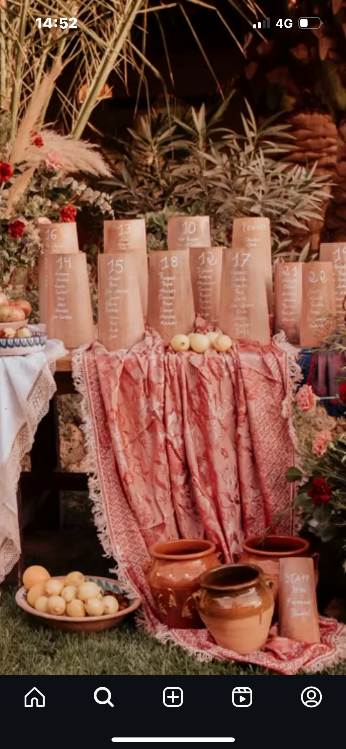 Una mesa con muchos jarrones y flores sobre ella.