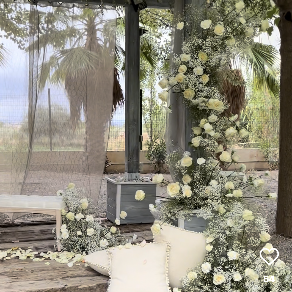 Una habitación llena de muchas flores blancas y almohadas.