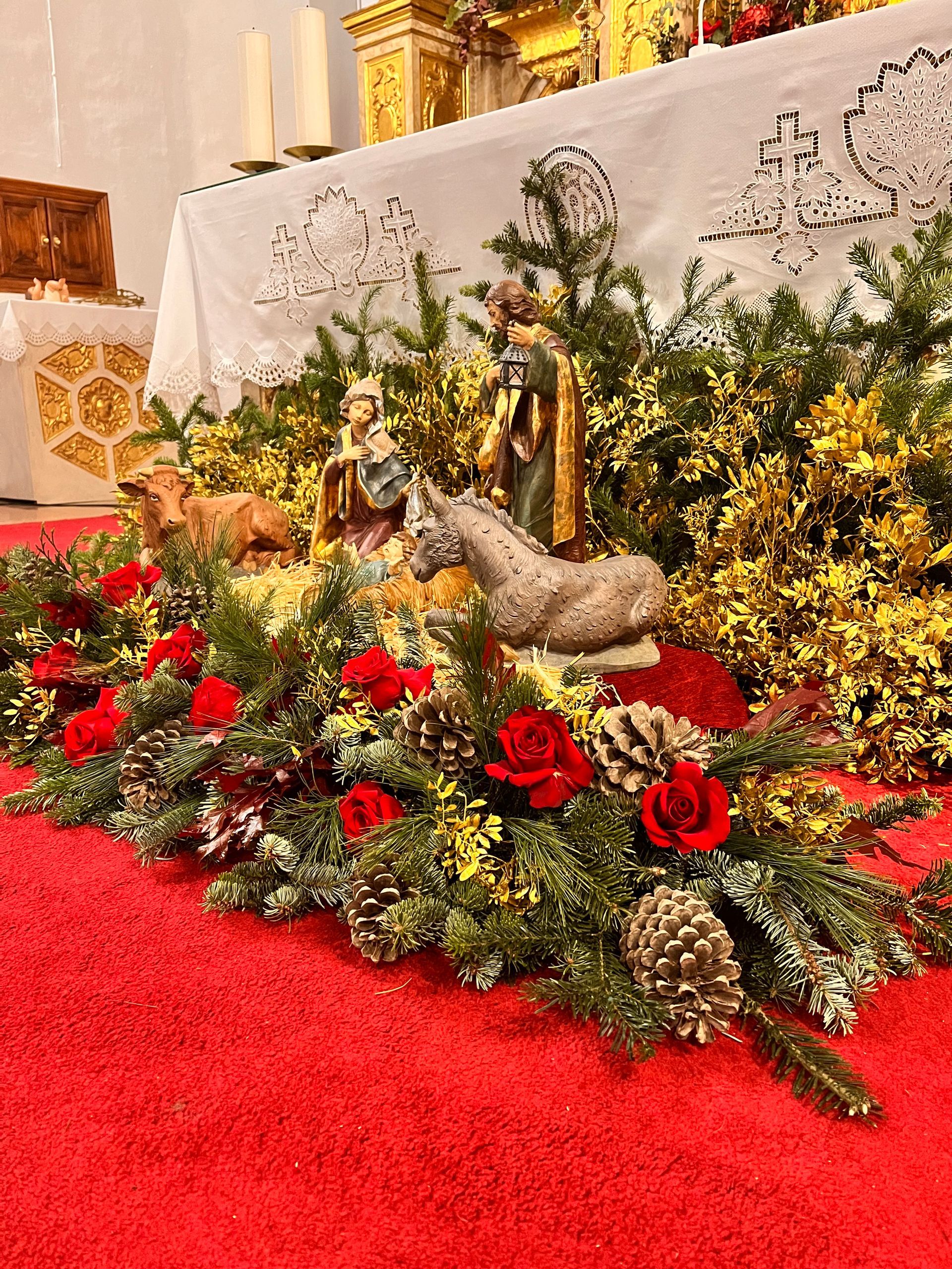 En el altar de una iglesia se exhibe un belén navideño.