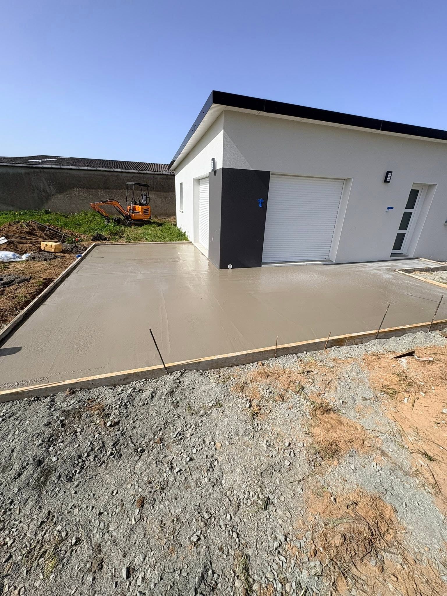 Maison blanche moderne avec allée en béton dans un cadre extérieur ensoleillé