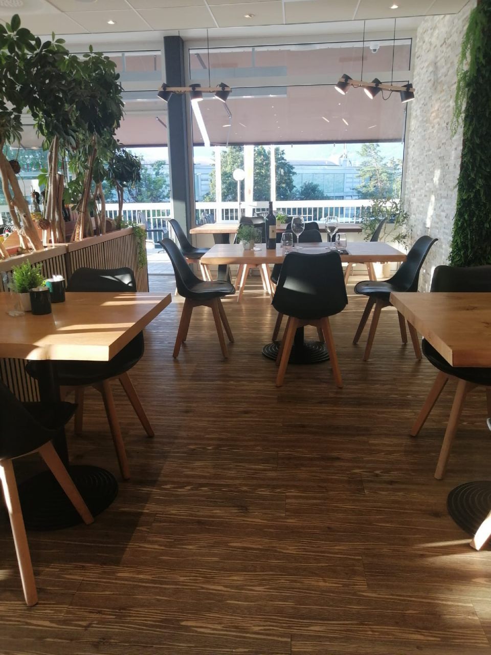 Un restaurant avec tables et chaises et une grande fenêtre