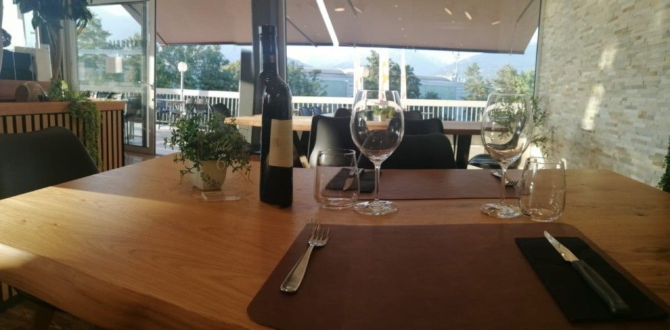 Une bouteille de vin est posée sur une table en bois dans un restaurant.