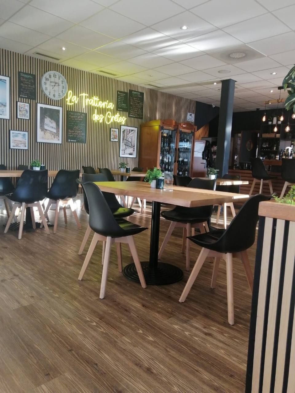 Un restaurant avec tables et chaises et une horloge au mur.