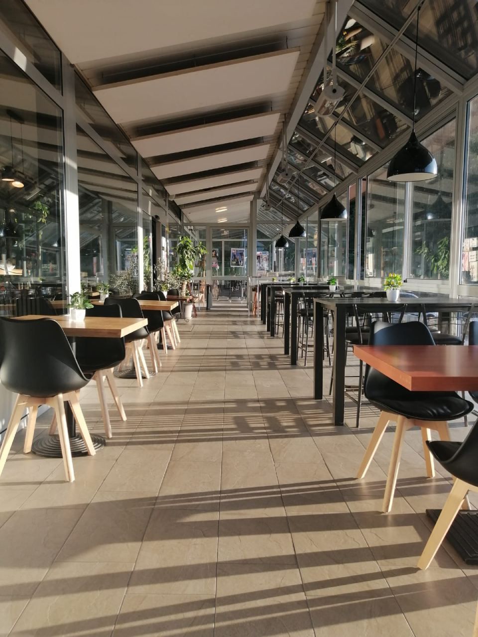 Un long couloir avec des tables et des chaises dans un restaurant.